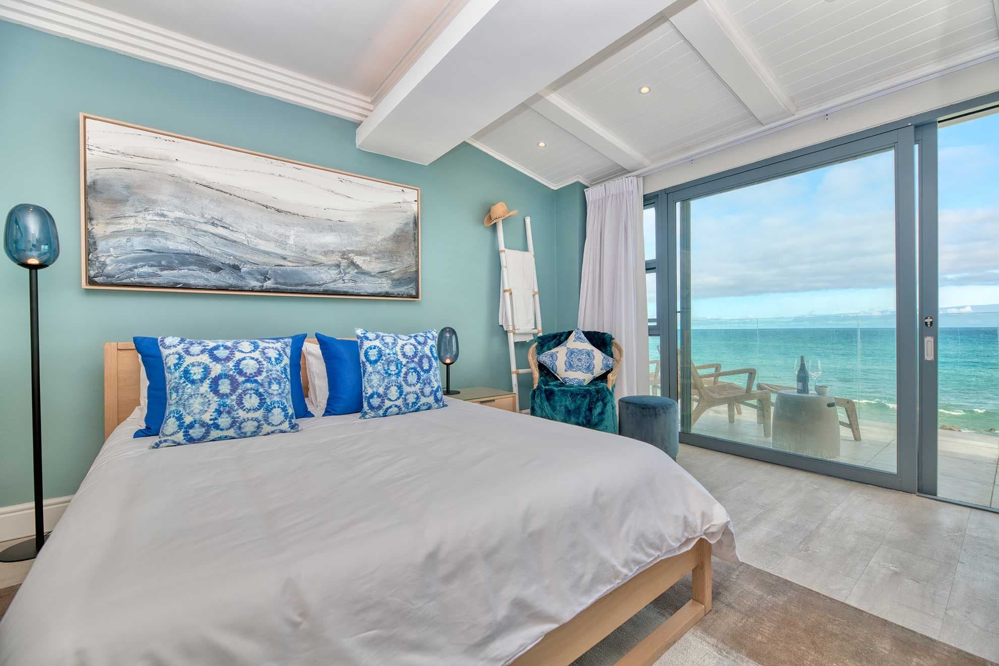 A king bedroom with its own sea-facing balcony set with wine glasses